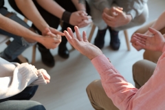Close-up of therapist\'s hands explaining a problem to his patients